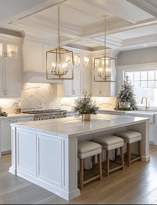 White kitchen with a large island and upholstered stools under brass lantern pendants and a coffered ceiling